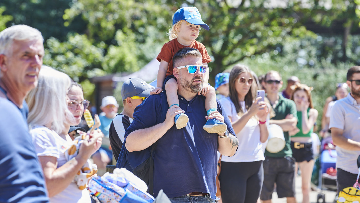 Dad with child on shoulders in crowd
