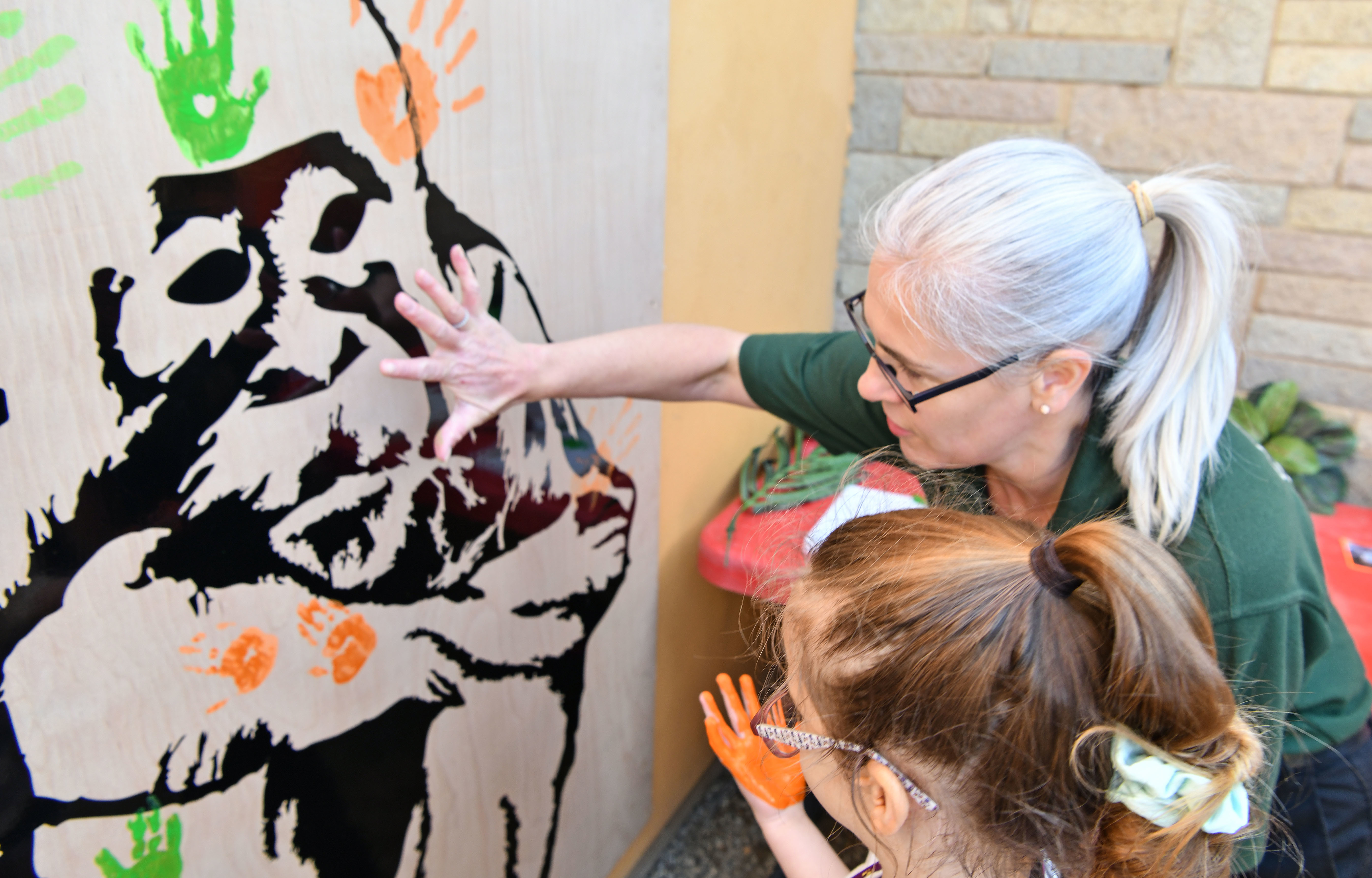 Child making mural with education ranger