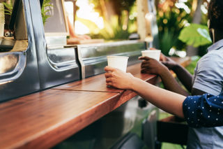 People Ording Drinks At Kiosk